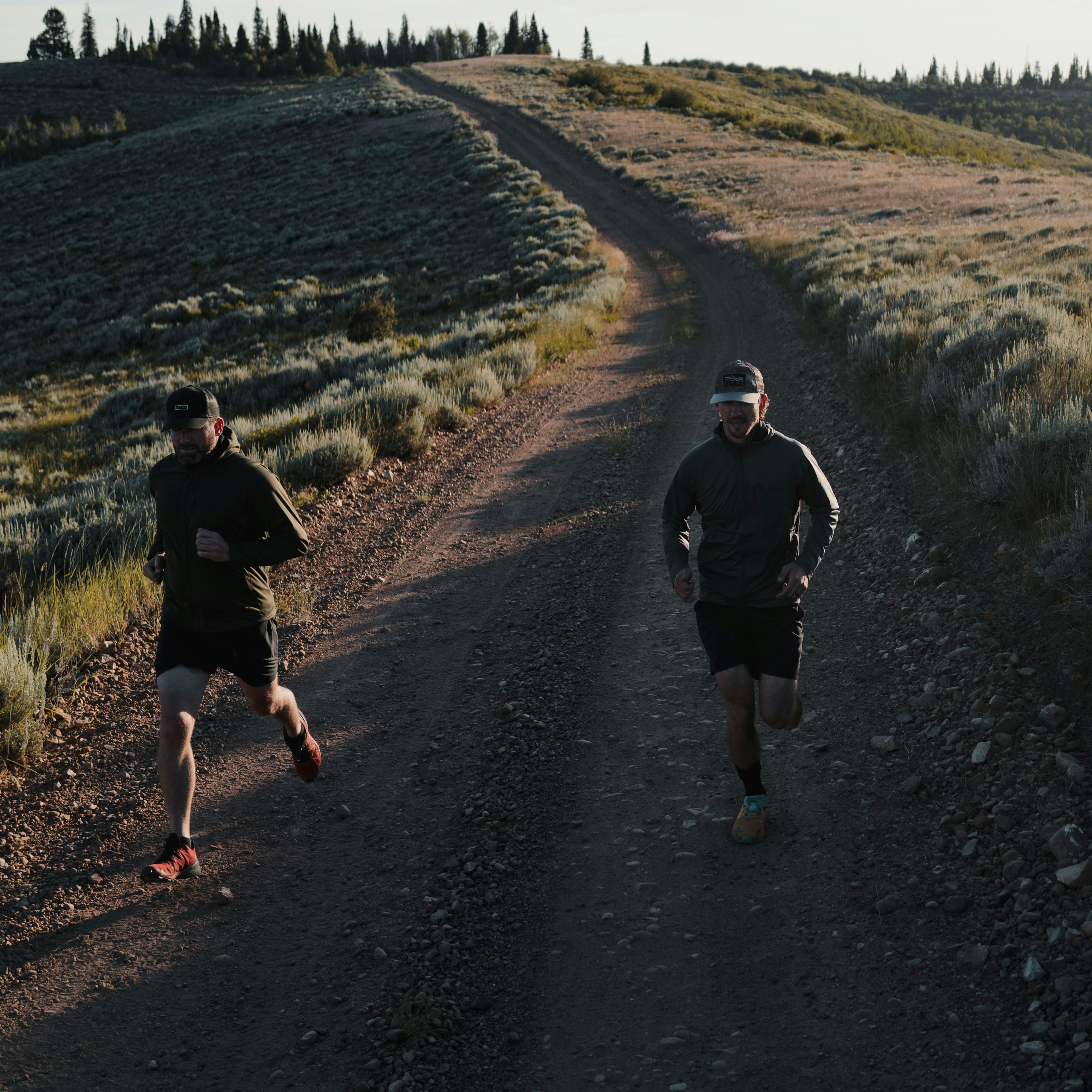 Christian Schauff and Haakon Johnson running down a dirt road in Utah in the Mountain Evo Jacket | SITKA Gear