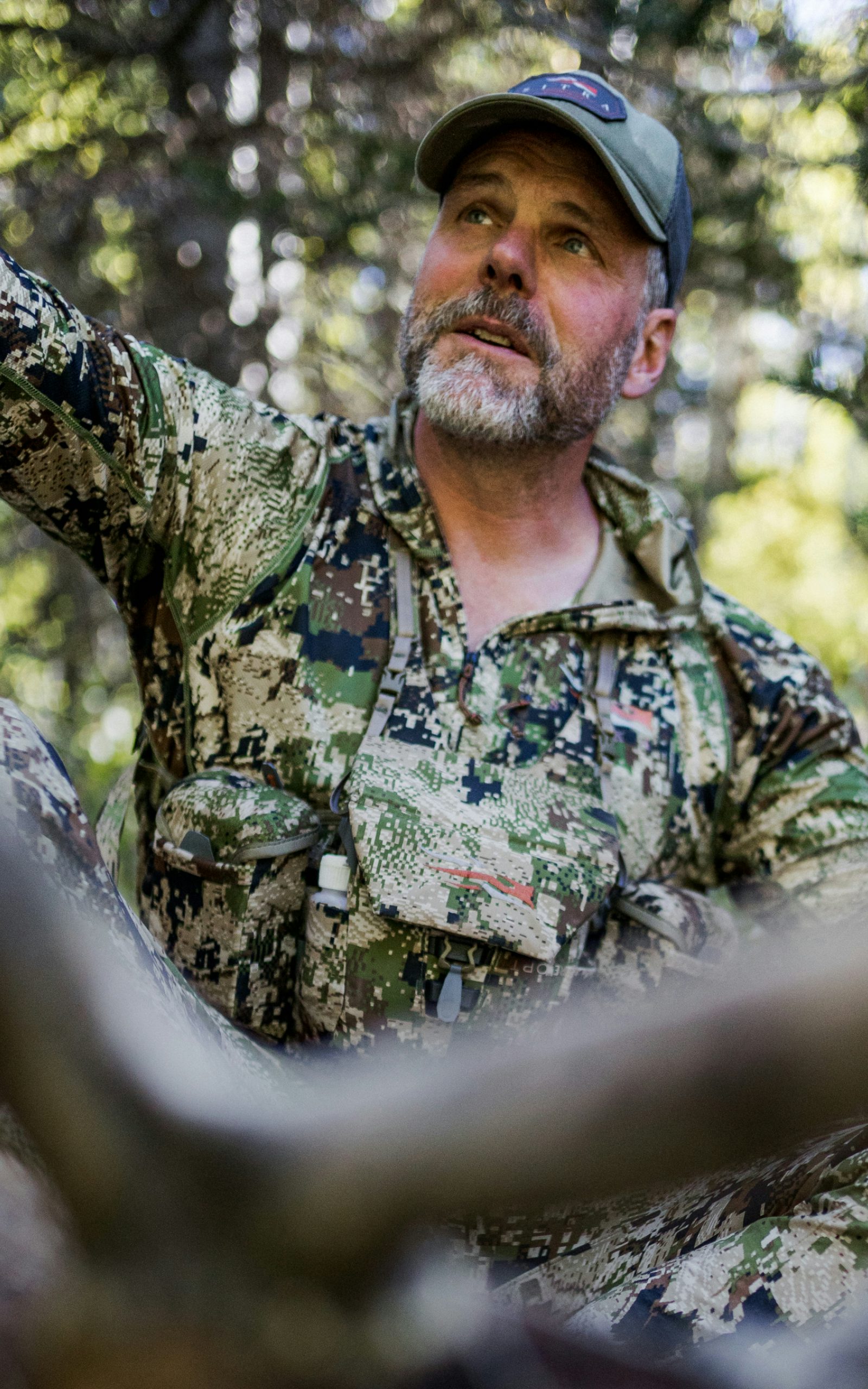 John Barklow holding onto the antlers of his harvested bull elk in Optifade Subalpine | SITKA Gear