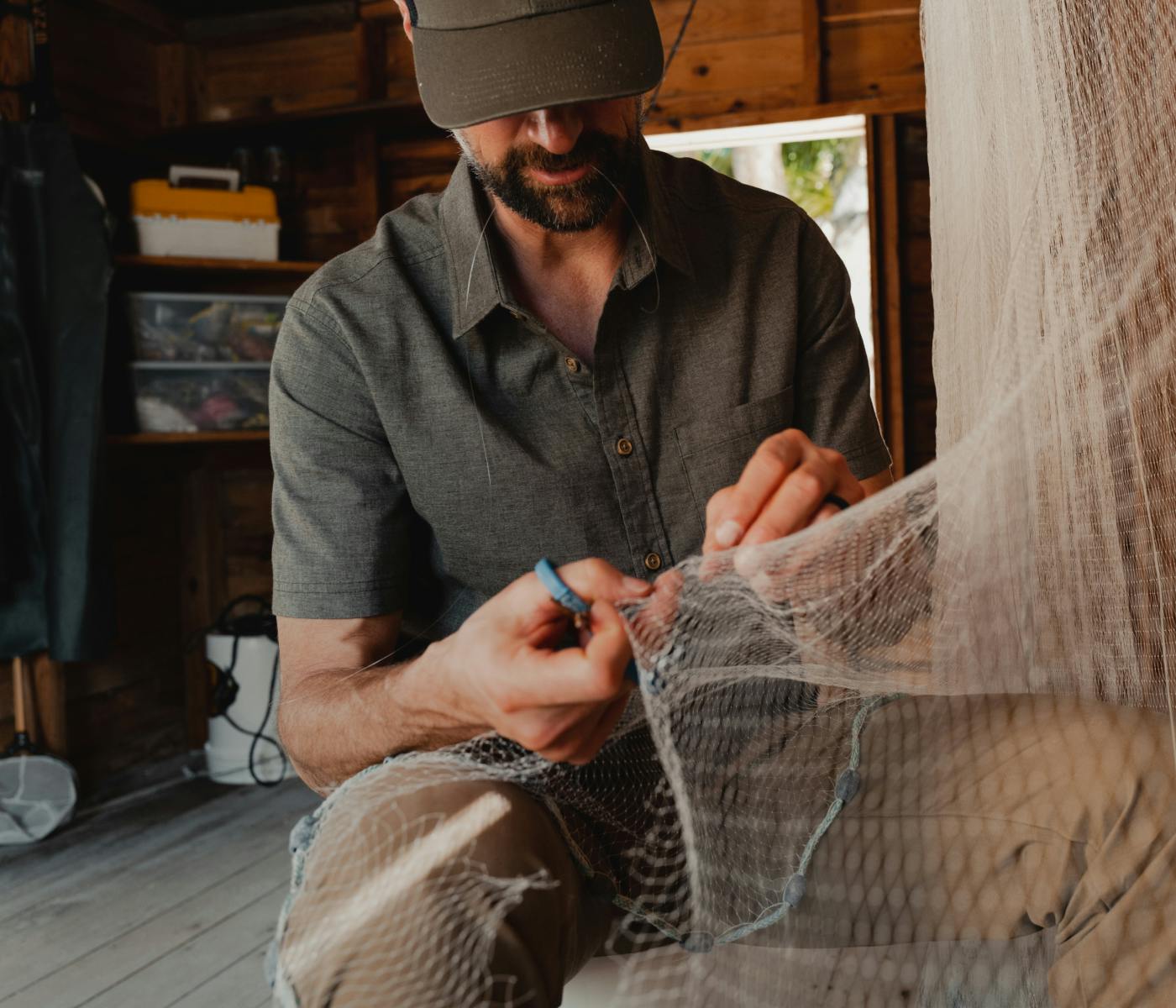 Man cutting a fishing net in the Ambary SS Shirt | SITKA Gear