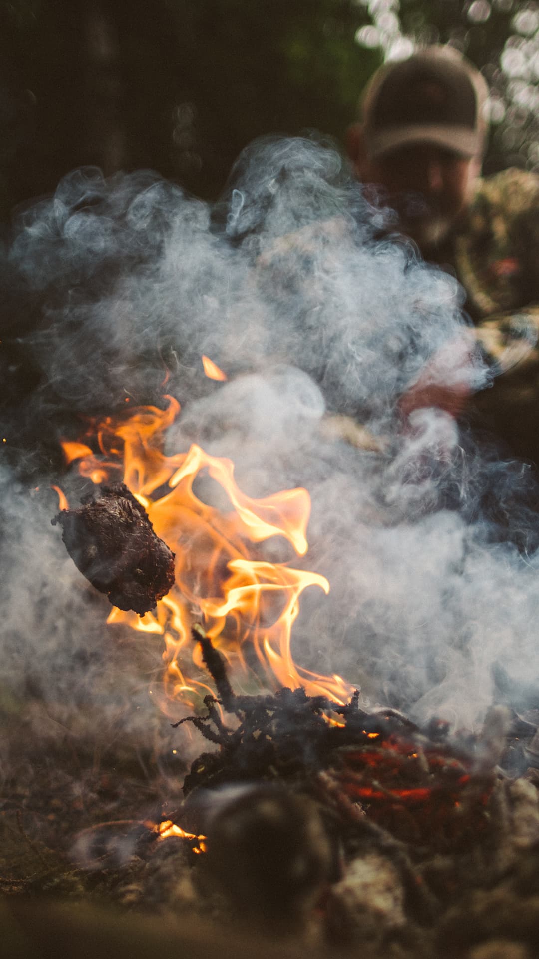 A man cooks over an open flame.