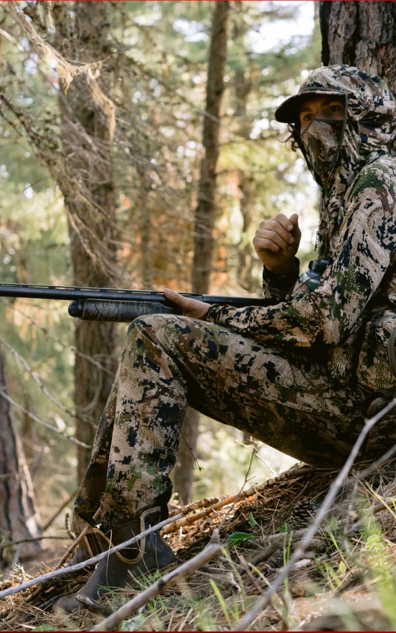 Beau Brooks sitting under a tree in the Equinox Guard Turkey System in Optifade Subalpine | SITKA Gear