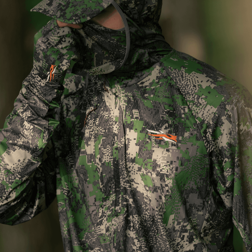 Man pulling up the integrated face mask on Equinox Guard Hoodie