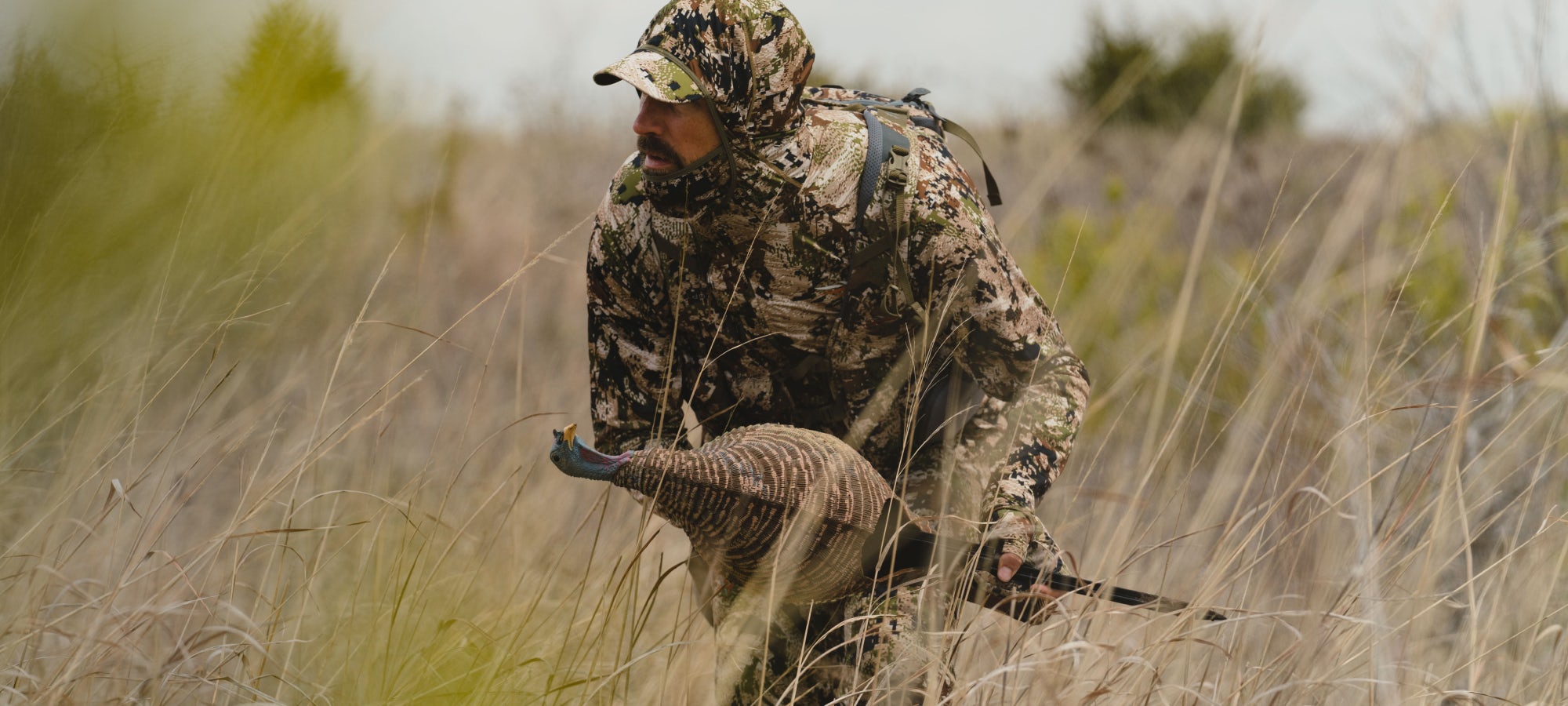 Man in the Equinox Guard System in Optifade Subalpine stalking throught the high grass after Turkey | SITKA Gear