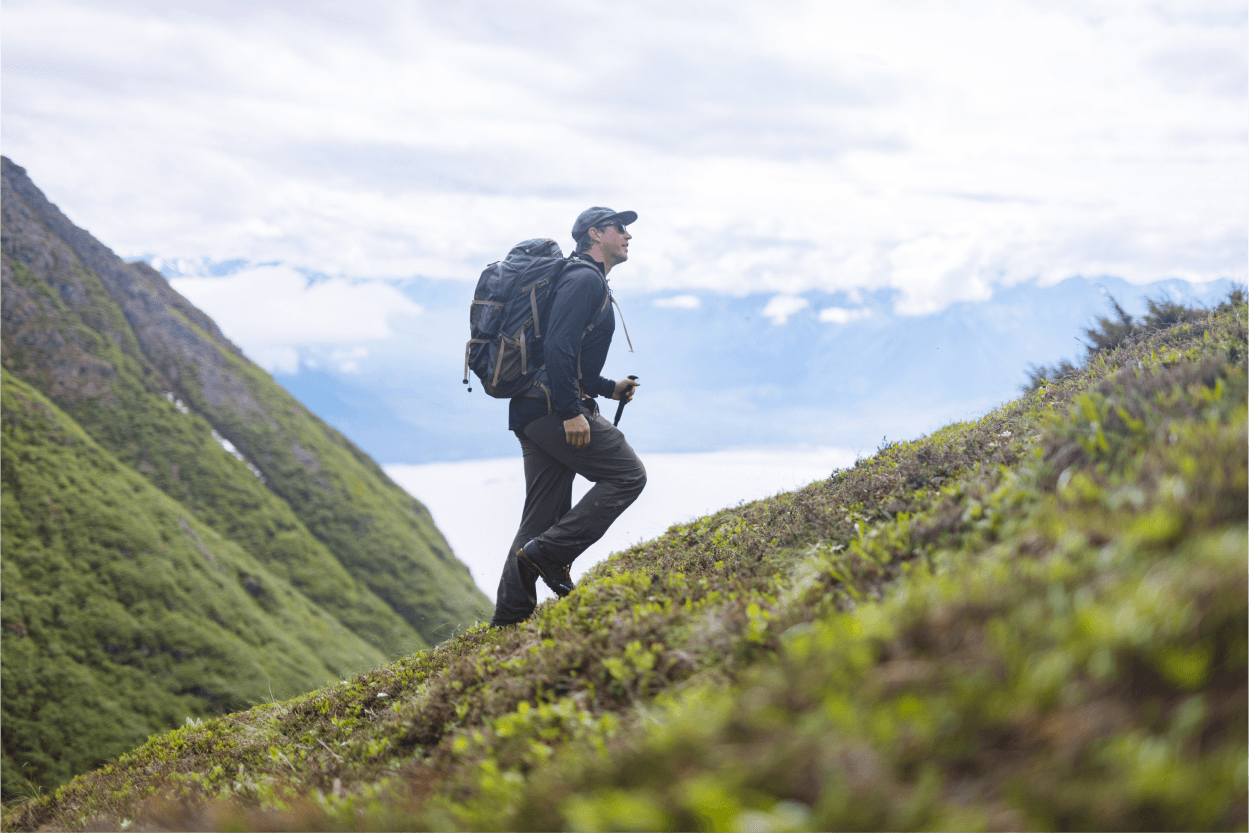 Man hiking up mountain in search of sheep | SITKA Gear