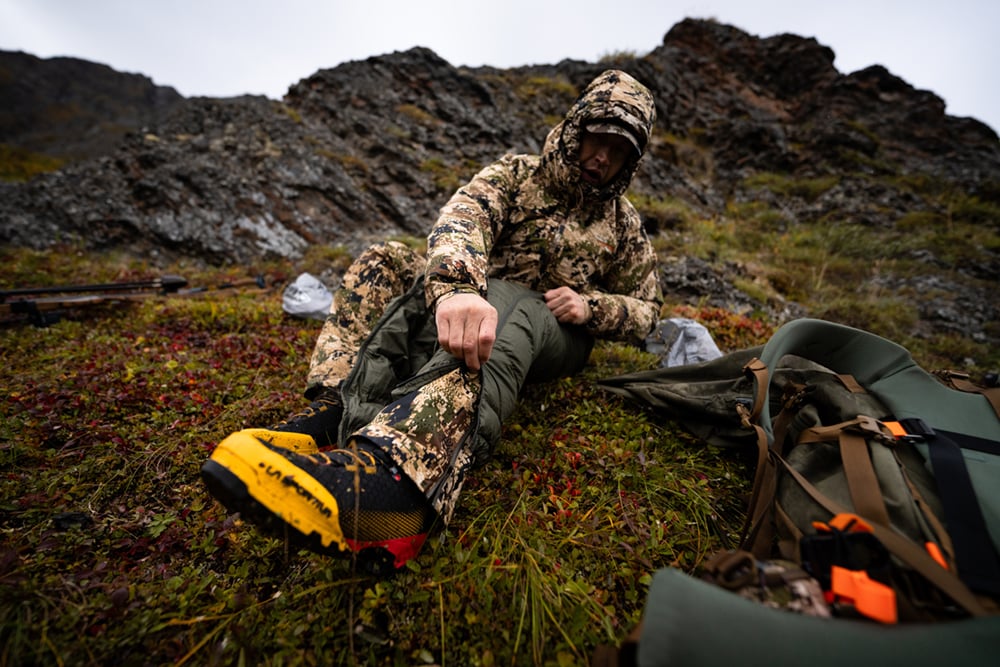 Paul Forward zipping up the HyperDown Pant in Deep Lichen | SITKA Gear